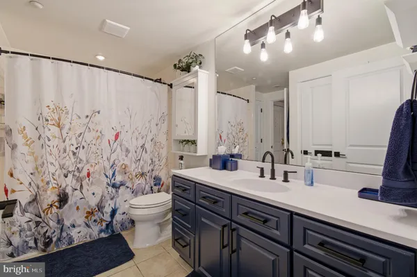 a bathroom with a double vanity sink toilet and a mirror
