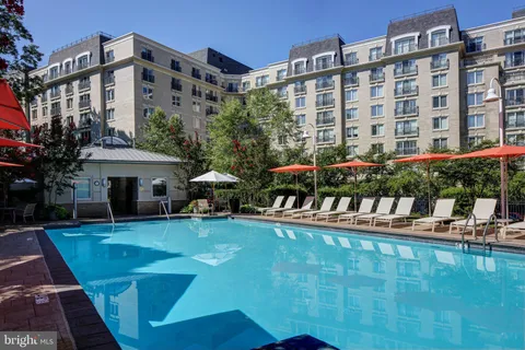 a view of a swimming pool with a table and chairs under an umbrella