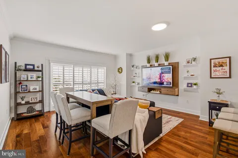 a living room with furniture a flat screen tv and a wall painting