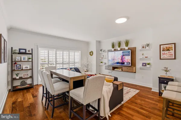 a living room with furniture a flat screen tv and a wall painting