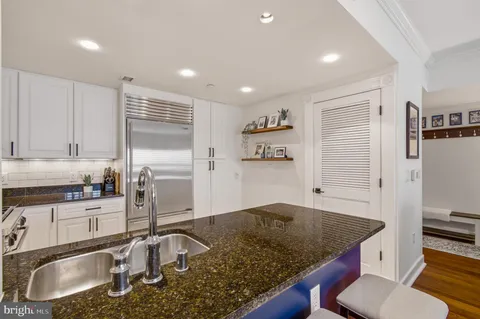 a kitchen with granite countertop a sink a stove and a wooden cabinets