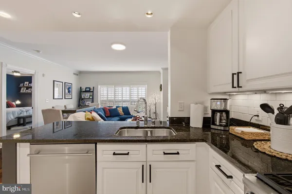 a kitchen with granite countertop a sink and cabinets