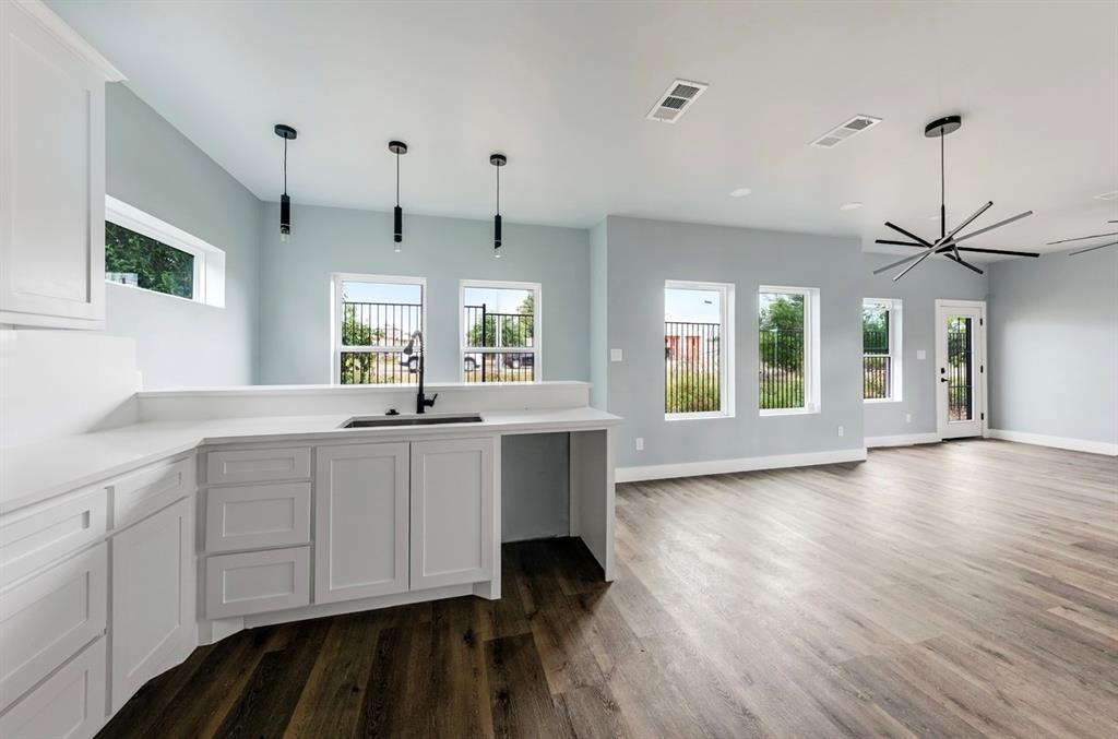 1113 East Oleander Street Fort Worth, TX 76104 - Photo 11 of 39 Kitchen with plenty of natural light, white cabinets, decorative light fixtures, dark wood finished floors, and recessed lighting