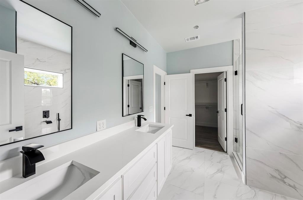 1113 East Oleander Street Fort Worth, TX 76104 - Photo 36 of 39 Full bath featuring a walk in closet, double vanity, light marble finish flooring, a wall unit AC, and a marble finish shower