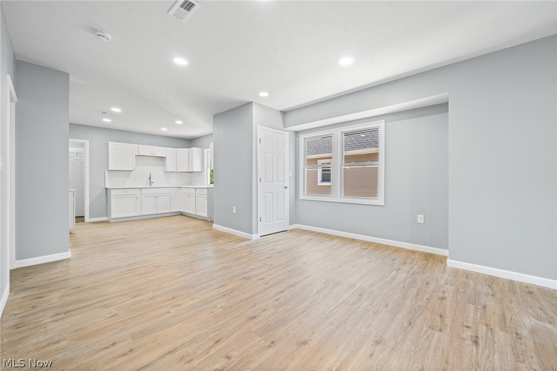 3925 Riverside Avenue Cleveland, OH 44109 - Photo 24 of 48 Open concept living area featuring wood-finish flooring, recessed lighting, and a modern kitchen with white cabinetry and a stainless steel sink