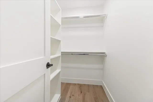 a view of walk in closet with empty racks