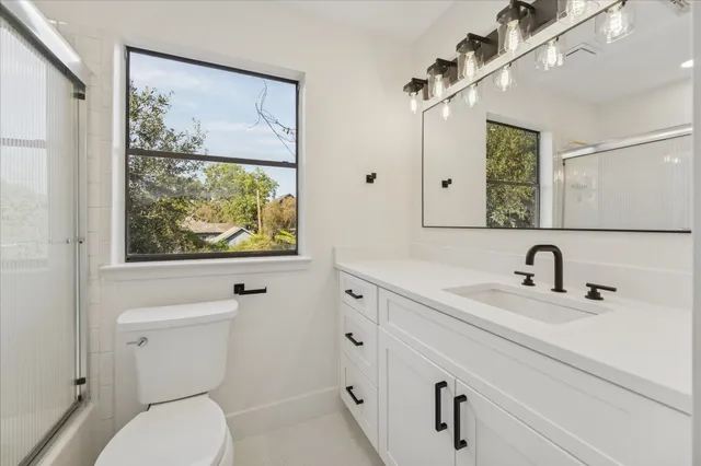 a bathroom with a toilet a sink and mirror