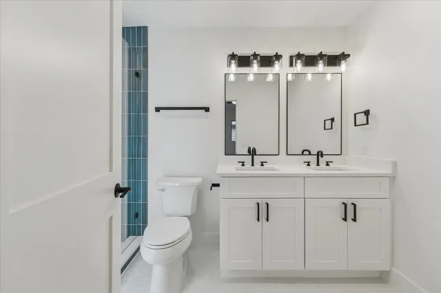 a bathroom with a sink a toilet and shower