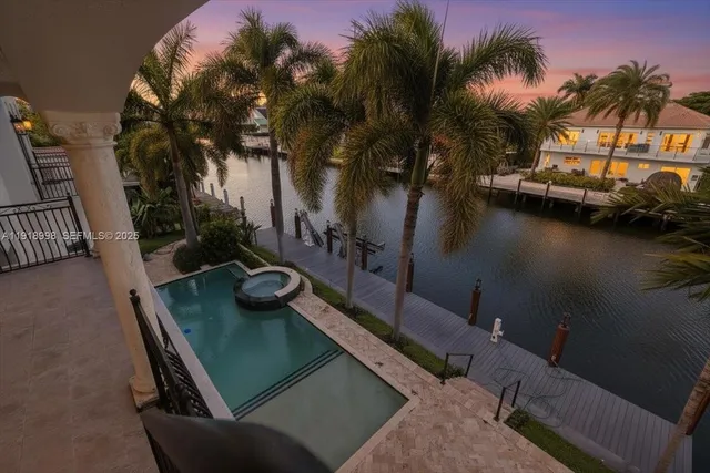 a view of a swimming pool with lounge chair and palm tree