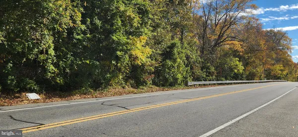 a view of a white house next to a road