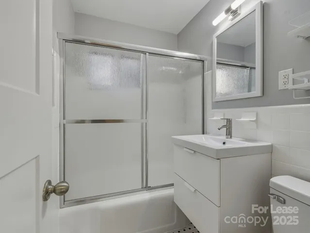a bathroom with a shower sink vanity and toilet