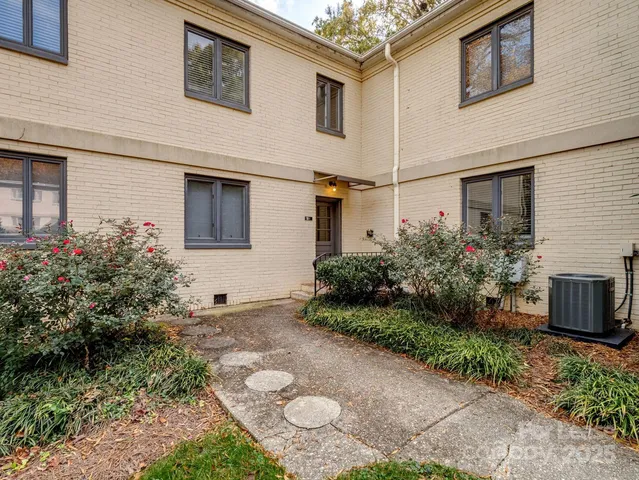 a view of a white house with a yard and plants