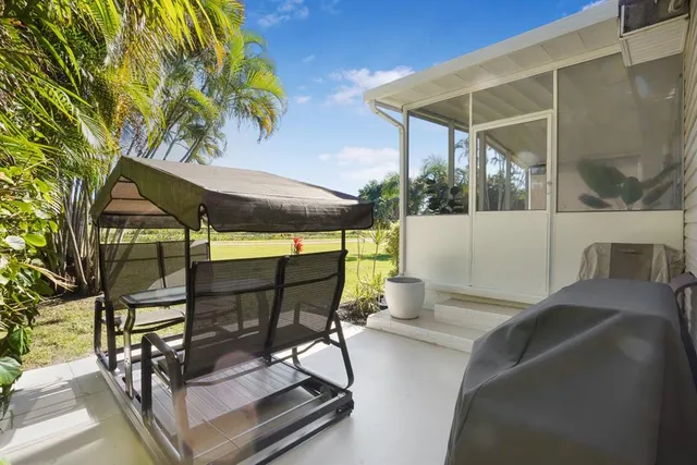a roof deck with table and chairs under an umbrella