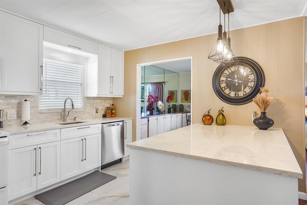 1830 Southwest 83rd Avenue Davie, FL 33324 - Photo 17 of 33 a kitchen with a sink a clock and cabinets