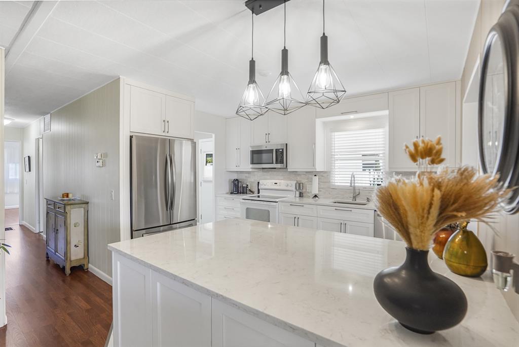 1830 Southwest 83rd Avenue Davie, FL 33324 - Photo 3 of 33 a kitchen with stainless steel appliances granite countertop a sink a refrigerator and couches