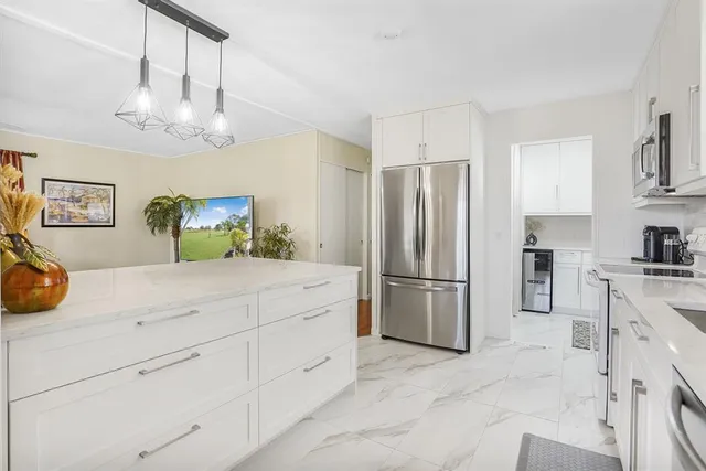 a kitchen with a refrigerator sink and cabinets