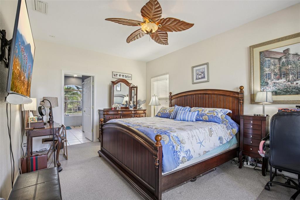 24567 Buckingham Way Punta Gorda, FL 33980 - Photo 17 of 46 a bedroom with a bed and a chandelier