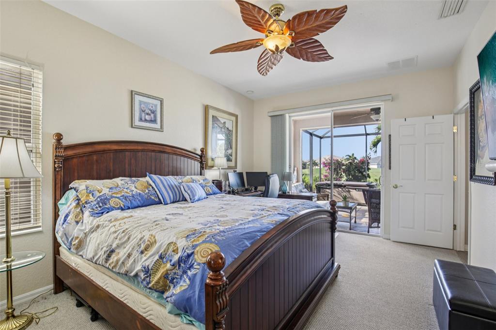24567 Buckingham Way Punta Gorda, FL 33980 - Photo 18 of 46 a bedroom with a large bed and a chandelier