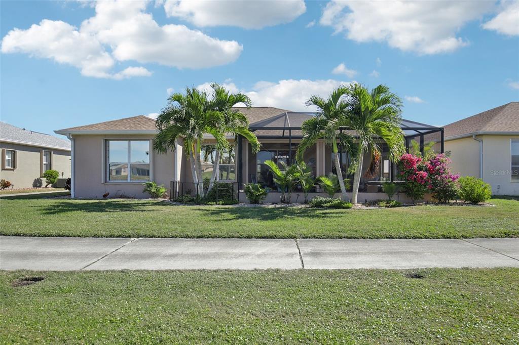24567 Buckingham Way Punta Gorda, FL 33980 - Photo 37 of 46 a front view of a house with a yard and palm trees