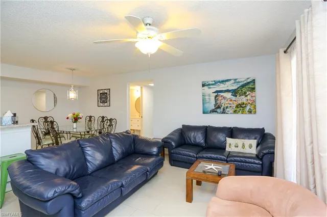 a living room with furniture ceiling fan and a window