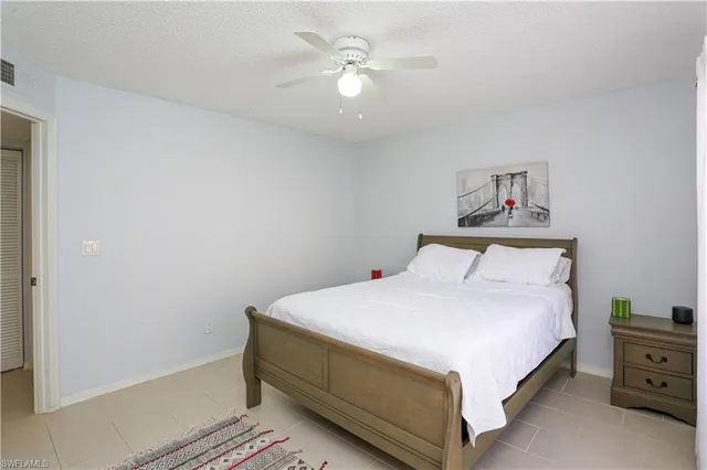 a bedroom with a bed and a chandelier fan