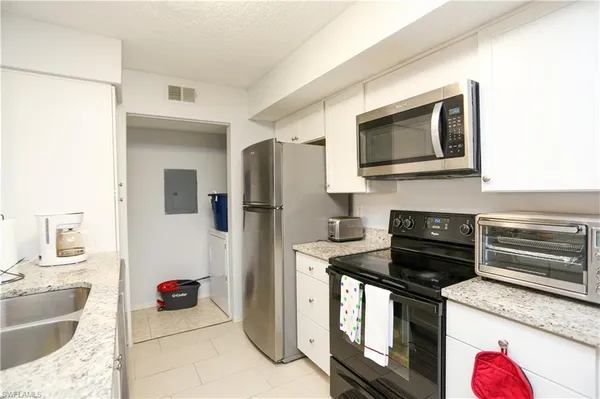 a kitchen with stainless steel appliances granite countertop a stove microwave and refrigerator