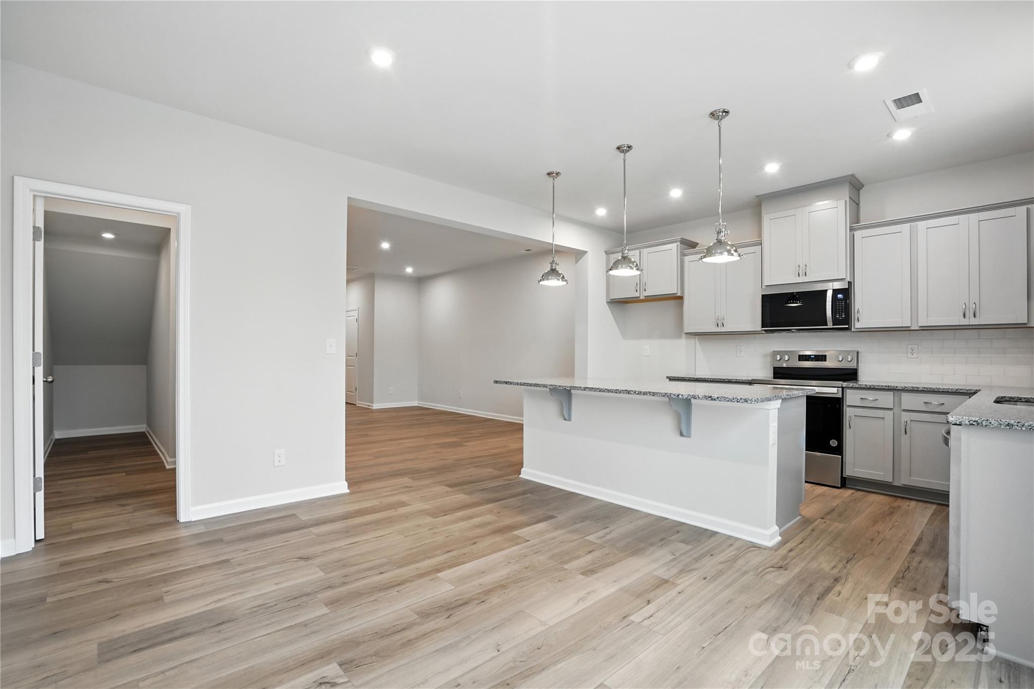 323 Laura Elizabeth Lane Clover, SC 29710 - Photo 5 of 28 a large kitchen with kitchen island a sink stainless steel appliances and cabinets