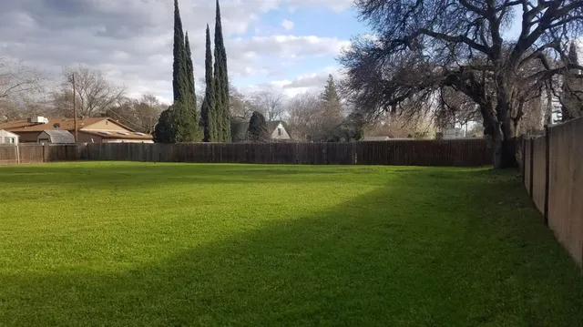 a view of a fountain in front of a house with a big yard