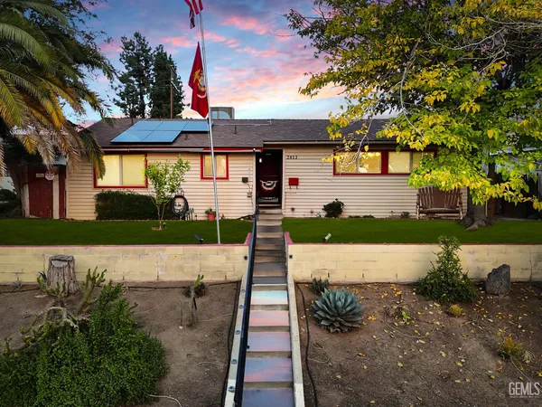 a front view of a house with a yard and potted plants