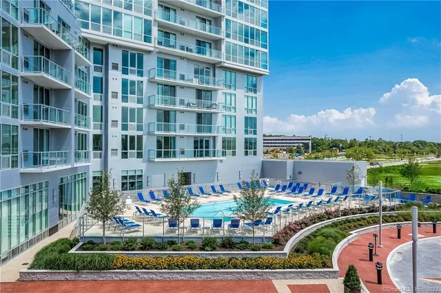 a front view of a building with a garden and seating