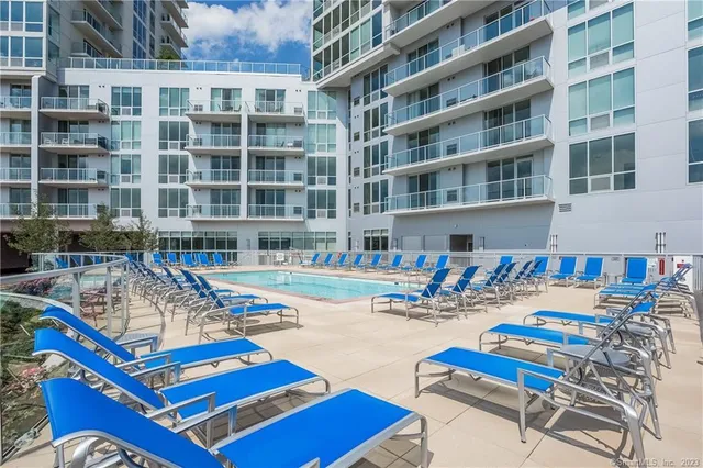 a front view of a building with swimming pool and sitting area