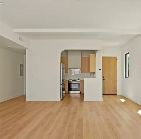 a view of empty room with wooden floor and fireplace