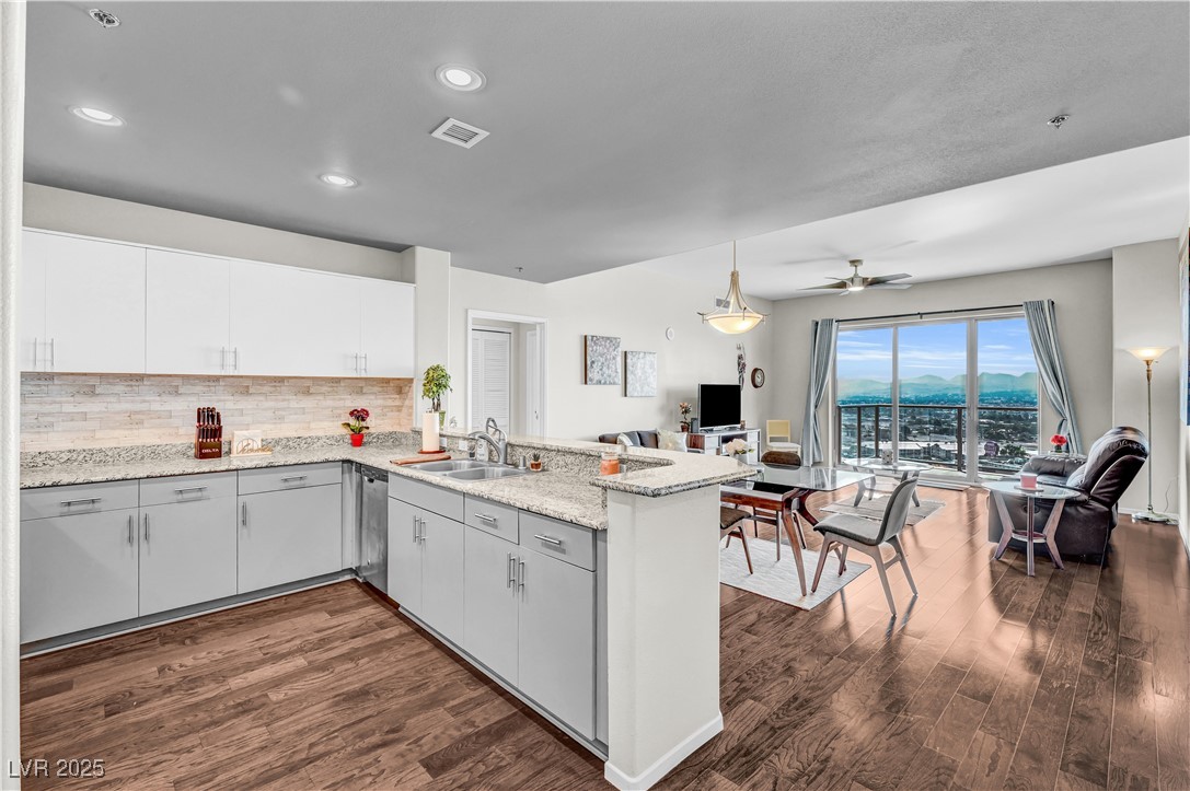 8255 South Las Vegas Boulevard, Unit 1715 Las Vegas, NV 89123 - Photo 48 of 49 Kitchen with open floor plan, backsplash, a breakfast bar, dark wood flooring, and recessed lighting