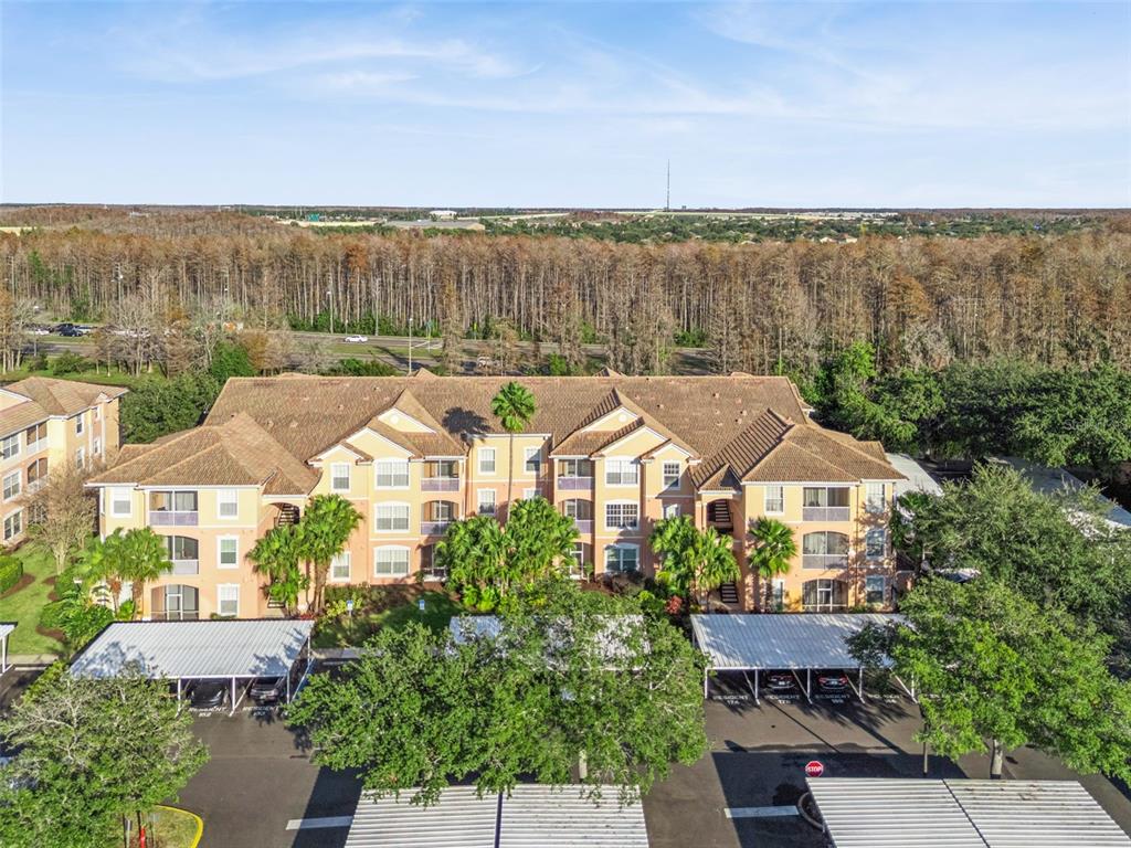13560 Turtle Marsh Loop, Unit 21 Orlando, FL 32837 - Photo 1 of 30 an aerial view of a house with a garden and lake view