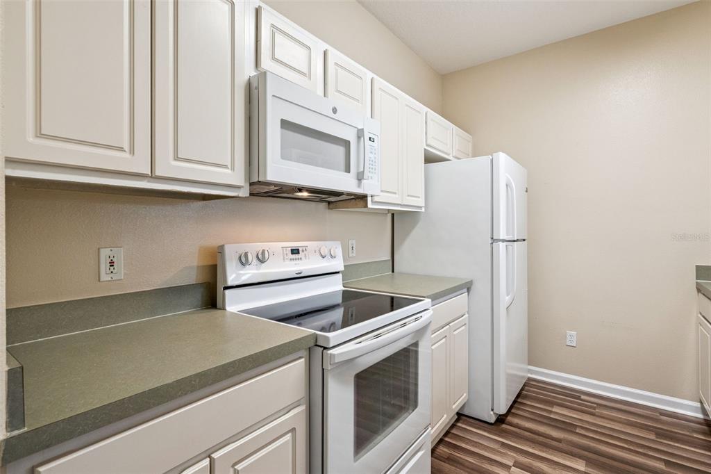 13560 Turtle Marsh Loop, Unit 21 Orlando, FL 32837 - Photo 9 of 30 a kitchen with stainless steel appliances white cabinets and a stove top oven
