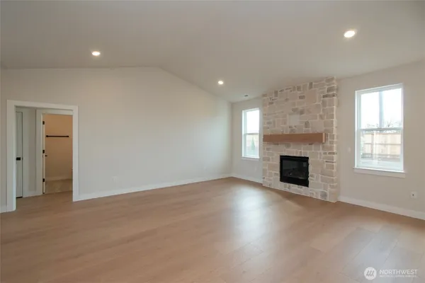 an empty room with windows and fireplace
