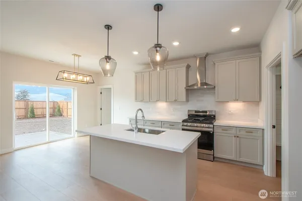 a kitchen with kitchen island a sink stainless steel appliances and cabinets