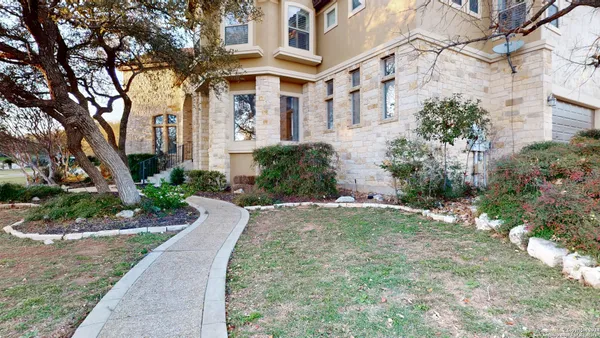 a front view of a house with a yard and tree s