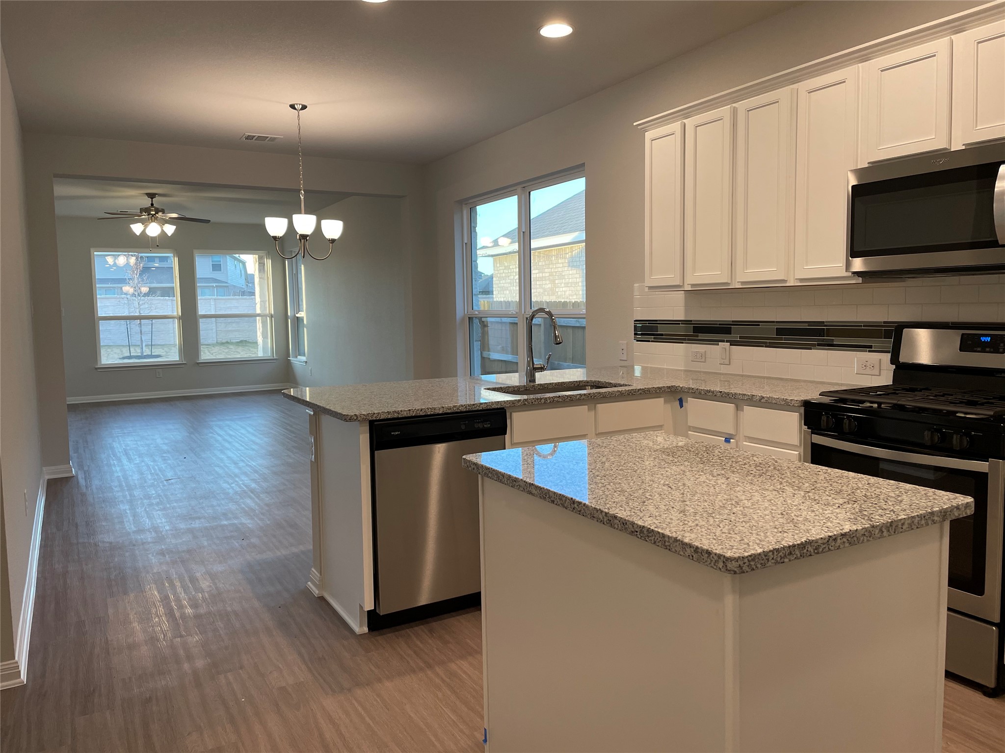 3908 Birdwatch Loop, Unit 56 Pflugerville, TX 78660 - Photo 30 of 30 a kitchen with stainless steel appliances granite countertop a sink a stove a microwave and island