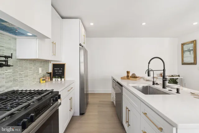 a kitchen with a sink and a stove top oven