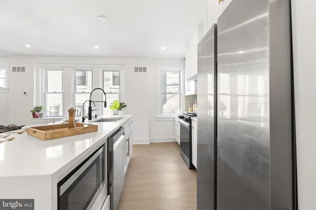 a kitchen with sink refrigerator and cabinets