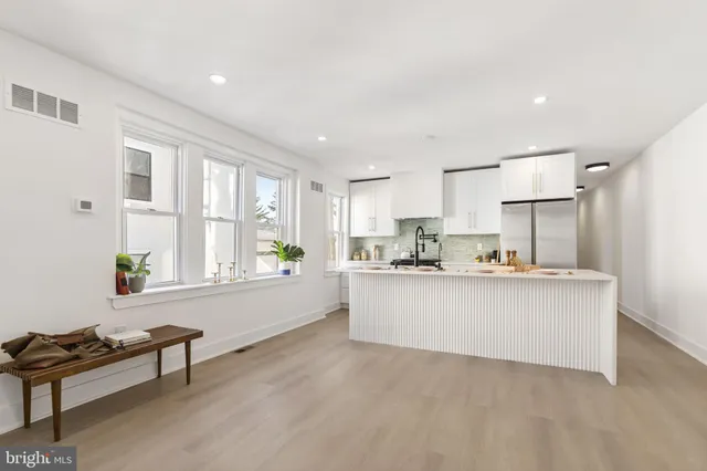 a living room with kitchen island furniture and a kitchen area