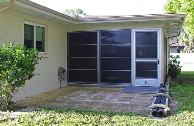 a view of backyard with potted plants and a large window