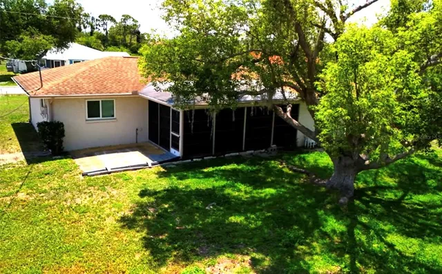 a front view of house with yard and trees in the background