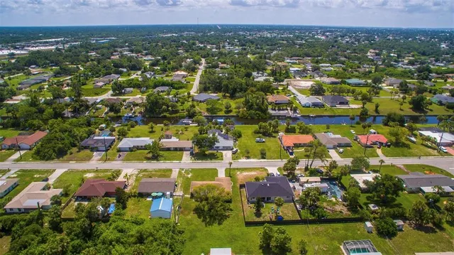 an aerial view of residential houses with outdoor space and trees