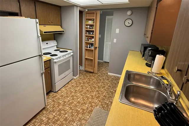 a kitchen with a refrigerator and a stove