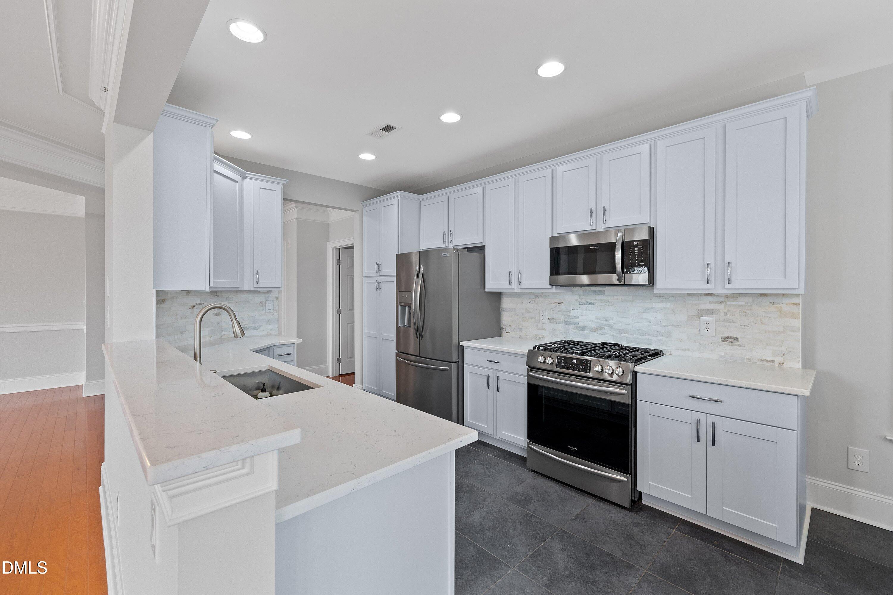 9211 Calabria Drive, Unit 205 Raleigh, NC 27617 - Photo 21 of 55 a kitchen with a sink a stove and refrigerator