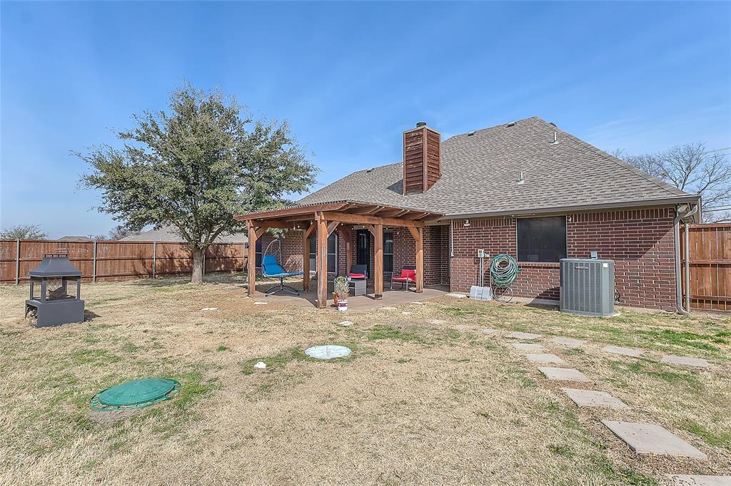 11151 County Road 213 Forney, TX 75126 - Photo 32 of 35 Rear view of property featuring roof with shingles, a fenced backyard, a patio, and a chimney