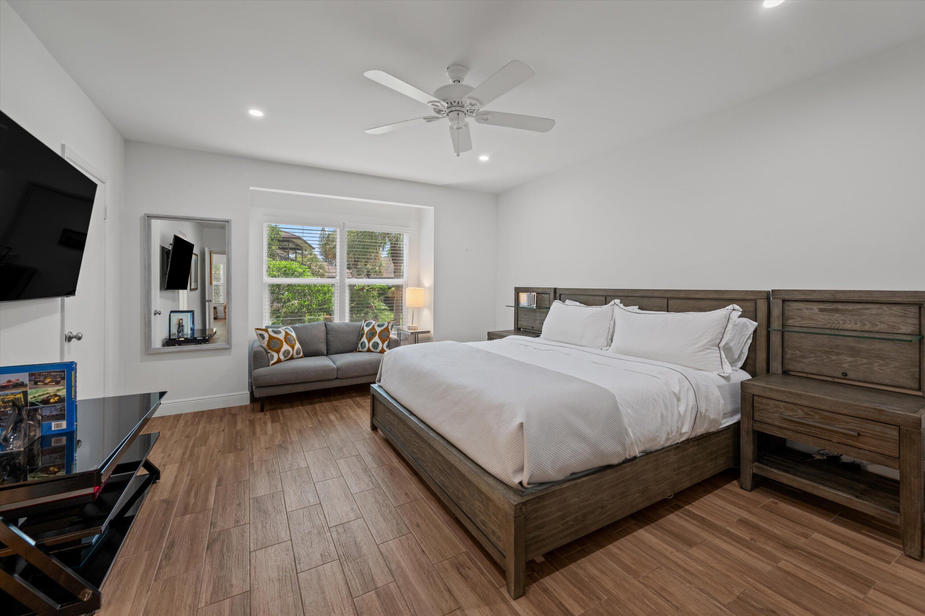 13400 Polo Road West, Unit 203 Wellington, FL 33414 - Photo 14 of 26 a bedroom with a bed a couch and a flat tv screen on the dresser