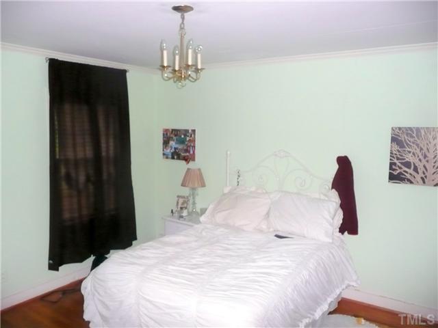 1706 Pineview Street Raleigh, NC 27608 - Photo 9 of 12 a bedroom with a bed and a chandelier